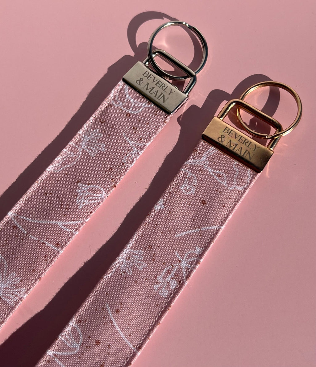 Light pink fabric keychains with floral print and key rings, perfect for gifting