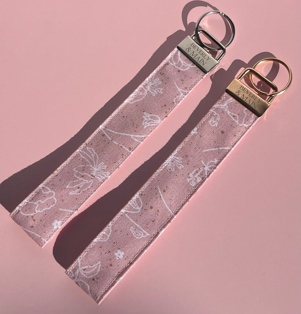 Handmade pink key fob wristlets with minimalist floral design on cotton fabric